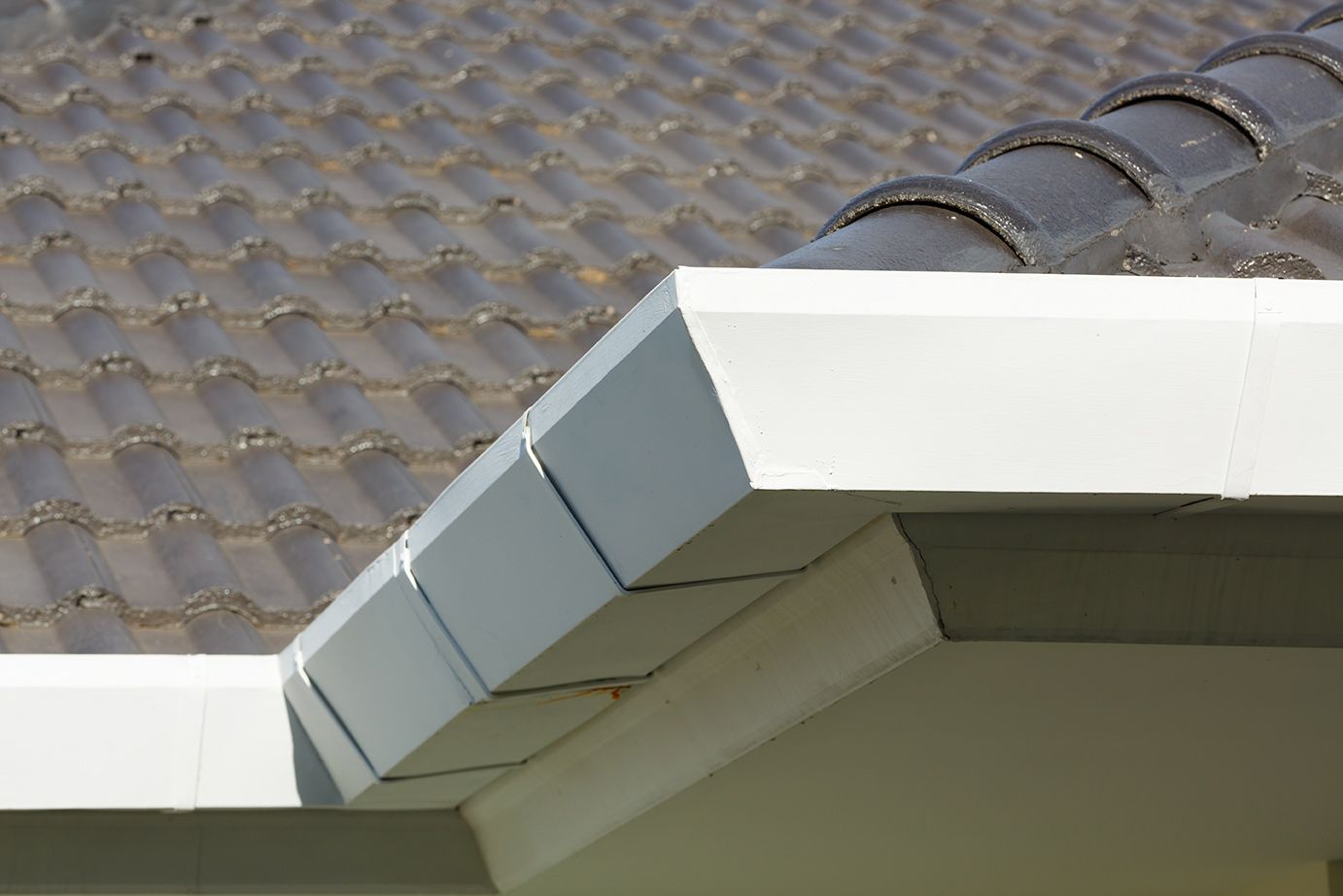 dark brown tile roof and white gutters installed on a Central Florida residential home by the local roofing company; Alan's Roofing.