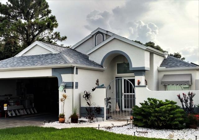 White brick home with a new roof installed by the local roofing company; Alan's Roofing in Spring Hill, FL.