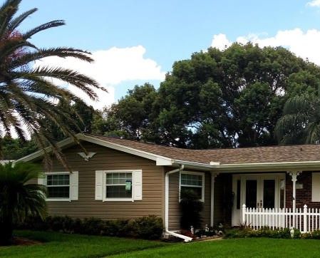 Brown house in central Florida with a new roof replacement installed by the local roofing company; Alan's Roofing.
