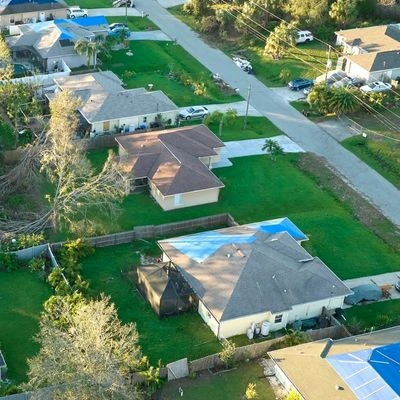 Aerial view of homes with emergency tarps on roofs after a storm