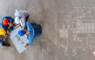 Aerial view of roofing contractors and homeowner reviewing roof replacement plans and Florida Building Code compliance requirements on construction site